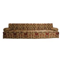 an old style couch with red flowers on it's back and seat cushioning