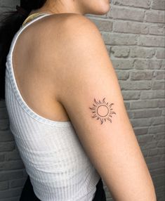 a woman with a small sun tattoo on her arm