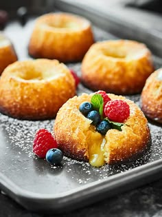 fresh baked donuts with berries and blueberries on a baking sheet, ready to be eaten