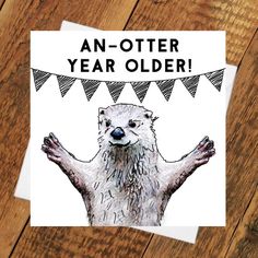 an otter birthday card with the words, an otter year older on it's front