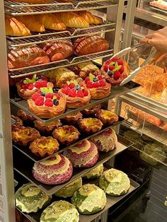 an assortment of pastries and desserts in a display case