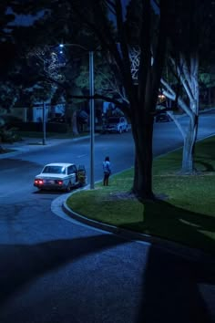 a car parked on the side of a road at night