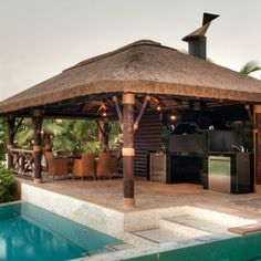 a gazebo next to a swimming pool with an outdoor kitchen