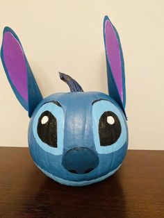 a blue and purple animal head sitting on top of a wooden table