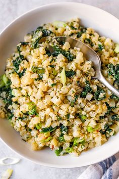 a white bowl filled with rice and broccoli