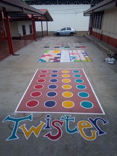 a big sign that says twister on the ground in front of a building with a car parked next to it