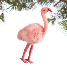 a pink flamingo ornament hanging from a pine tree