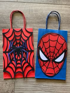 two paper bags with spiderman faces on them, one is blue and the other is red