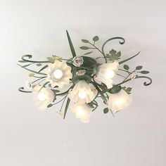 a chandelier with white flowers and green leaves