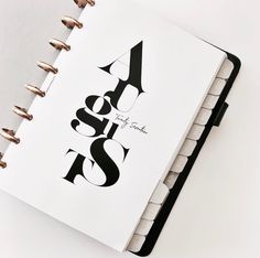 an open spiral notebook with black and white lettering