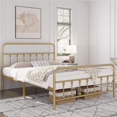 a bedroom with white walls and gold bed frame