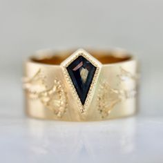 a gold ring with a black diamond in the center