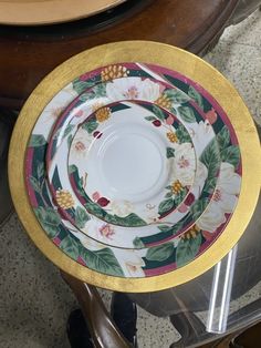 a stack of plates sitting next to each other on top of a wooden table in a room