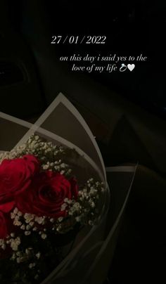 a bouquet of red roses sitting on top of a car dashboard