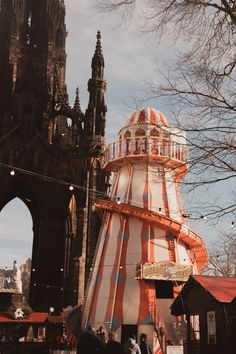 people are walking around in front of an old building with a circus tent on it