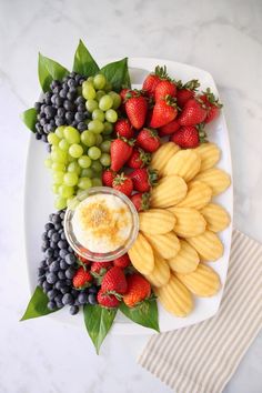 a platter filled with fruit and dip