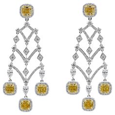 A well-crafted earrings showcasing eight cushion cut fancy yellow diamonds, set in a brilliant diamond halo in an Intricately designed chandelier style. Yellow Diamonds weigh 4.98 carats total; white diamonds weigh 4.41 carats total. Finely made in 18K white gold. Roman Malakov is a custom house, specializing in creating anything you can imagine. If you would like to receive a special quote on a custom piece please message or call us.