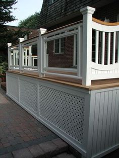 a house with white railings and brick walkway