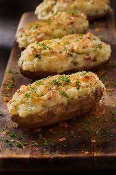 baked potatoes with cheese and herbs on a wooden cutting board