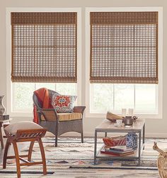 a living room filled with furniture and windows covered in bamboo blind shades on top of them