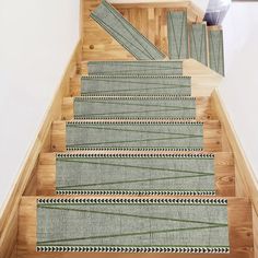 the stairs are made of wood and have green rugs on them