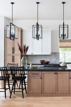 a kitchen filled with lots of counter top space and wooden flooring next to an island