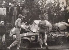 an old black and white photo of people standing around a car that is upside down