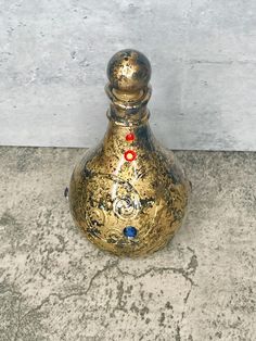 a gold vase sitting on top of a cement floor