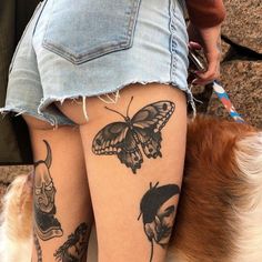 a woman with tattoos on her legs next to a dog