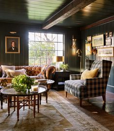 a living room with couches, chairs and pictures hanging on the wall behind them