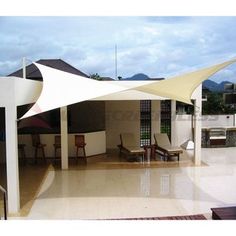 an outdoor area with chairs and tables under a white awning on the outside patio