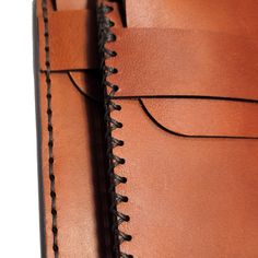 the inside of a brown leather wallet with stitching on it's sides and an opening