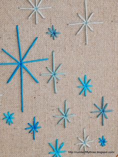 blue and white snowflakes are on a piece of fabric next to scissors