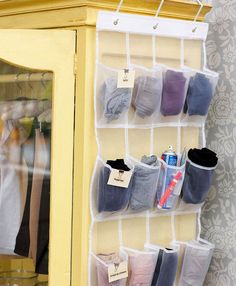 a yellow cabinet with several pairs of socks hanging on it