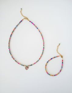 This exquisite choker necklace showcases a captivating blend of geometric patterns and vibrant hues. Crafted with a harmonious mix of gold accents, iridescent glass beads, and circular elements fromgold hematite, it exudes a luxurious and exclusive charm. Adorned with a heart pendant embellished with delicate floral motifs in soft turquoise and blush pink, this piece stands out as a truly unparalleled creation on the market. For those seeking to accentuate their facial features and illuminate th Multicolor Beaded Necklaces With Heart Charm As Gift, Multicolor Beaded Necklace With Heart Charm As Gift, Multicolor Heart Beads Jewelry For Festival, Multicolor Jewelry With Heart Charm And Round Beads, Festival Multicolor Heart Beads Jewelry, Adjustable Heart-shaped Multicolor Necklaces, Adjustable Multicolor Necklace With Heart Charm, Adjustable Heart-shaped Multicolor Necklace, Adjustable Multicolor Heart Charm Necklace