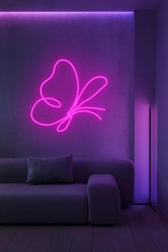 a living room with purple lighting and a butterfly wall decal on the wall above it