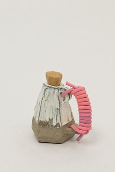 a small white and pink object with a cork top on it's back end