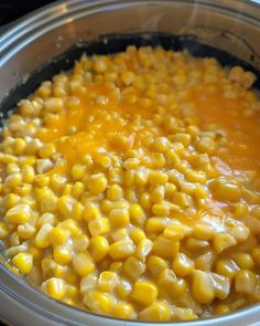 a bowl filled with corn sitting on top of a stove