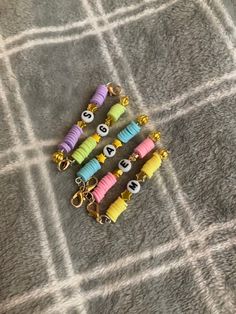 four different colored beads with numbers on them sitting on a gray blanket next to each other