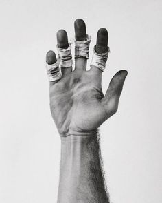 a person's hand with rings and nails on it, in front of a white background