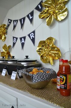 a table topped with food and condiments on top of a wooden counter covered in gold foil