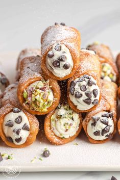 there are many pastry rolls with chocolate chips on them and sprinkled with powdered sugar