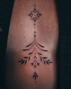 a woman's back with an arrow tattoo on her left side ribcage