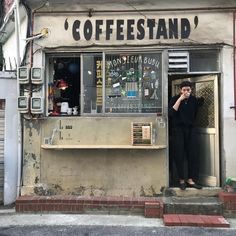 a woman standing in the doorway of a coffee shop