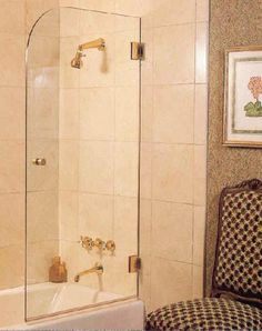 a bath tub sitting next to a white toilet in a bathroom under a framed picture