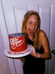 a woman holding a cake with the words dr pepper on it