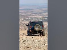 a jeep is parked on the side of a rocky hill in the middle of nowhere