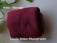 a close up of a red cloth on a table with a plant in the background