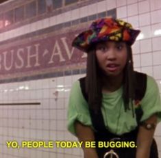 a woman standing in front of a wall with words on it that say, yo people today be bugging