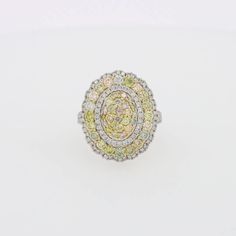 a yellow and white diamond ring sitting on top of a table